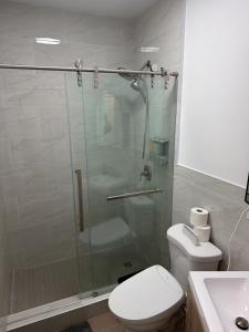 a bathroom with a shower with a toilet and a sink at The Revival Guest House near Times Square in New York