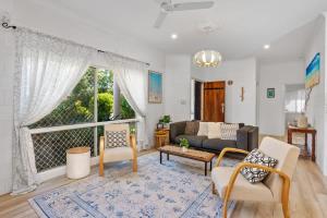 a living room with a couch and a window at Trinity Charm - Beachside Family Getaway with Pool in Trinity Beach