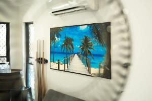 a picture of a beach with palm trees on a wall at Tropical Dreams - Spacious Retreat with Private Pool in Smithfield +18 photos