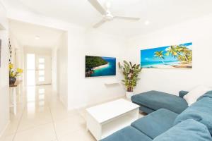 a living room with a blue couch and a painting at Tropical Dreams - Spacious Retreat with Private Pool in Smithfield