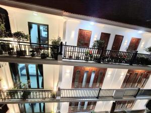 a large white building with balconies and doors at Cong Hoa Homestay in Vũ Lâm