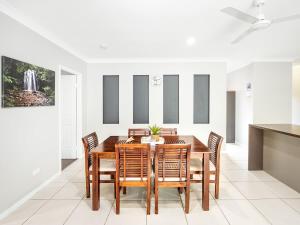 a dining room with a wooden table and chairs at Tropical Pool Sanctuary in Kewarra Beach, Family and Dog Friendly in Kewarra Beach