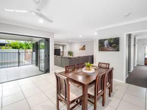 a dining room with a wooden table and chairs at Tropical Pool Sanctuary in Kewarra Beach, Family and Dog Friendly in Kewarra Beach