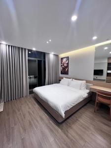a bedroom with a large white bed and a desk at SunQ Haven in Meyhomes in Phú Quốc +25 photos