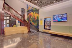 a lobby with a staircase and a painting on the wall at ibis Styles Kingsgate Melbourne in Melbourne