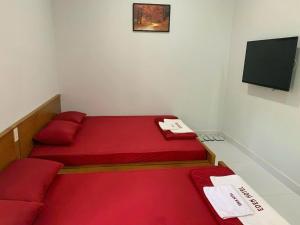 a small room with two beds and a flat screen tv at Khách sạn EDEN Chơn Thành in Chơn Thành