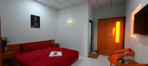 a small room with a red bed and a chair at Khách sạn EDEN Chơn Thành in Chơn Thành