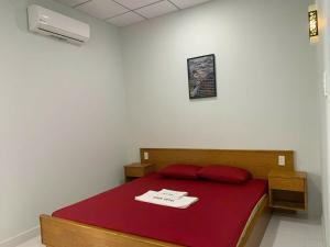 a bedroom with a bed with a red bedspread and amitted at Khách sạn EDEN Chơn Thành in Chơn Thành