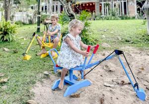 two young children playing in a play set in a yard at Proud Phu Fah Maerim Resort in Mae Rim