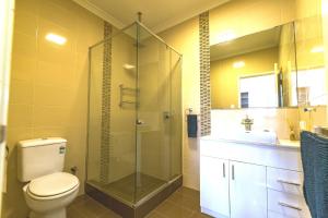 a bathroom with a shower and a toilet and a sink at Marina Views Mindarie in Mindarie +8 photos