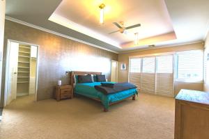 a bedroom with a bed and a ceiling fan at Marina Views Mindarie in Mindarie