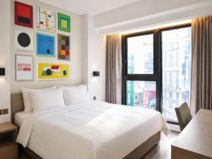 a bedroom with a white bed and a window at Innk in Taichung
