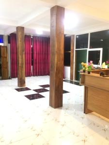 a lobby with columns and red curtains at Hotel Athina & Restaurant in Chilaw