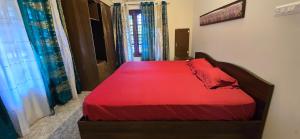 a bedroom with a bed with a red bedspread at K Apartment in Varkala