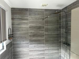 a bathroom with a shower with gray tiles at Banana Tree Lodge in Jamestown +14 photos