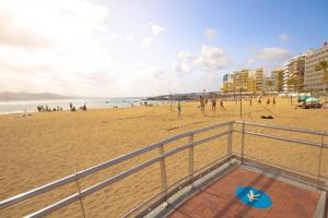 a group of people on a beach near the ocean at Hostel Tropical Work in Las Palmas de Gran Canaria