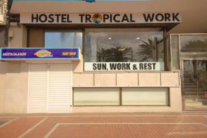 a store front with two garage doors and a sign at Hostel Tropical Work in Las Palmas de Gran Canaria