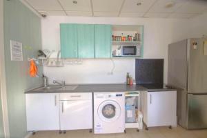 a kitchen with a washing machine and a sink at Hostel Tropical Work in Las Palmas de Gran Canaria