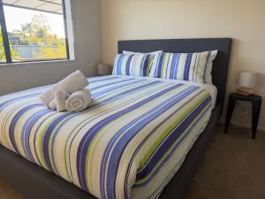 a bedroom with a bed with towels on it at The Bach in Coromandel Town