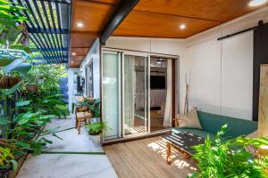 a living room with a green couch and some plants at Studio 55 in Mudjimba