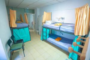 a small room with two bunk beds and a chair at Hostel Tropical Work in Las Palmas de Gran Canaria +3 photos