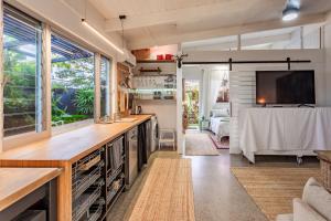 a kitchen and living room with a tv in a tiny house at Studio 55 in Mudjimba
