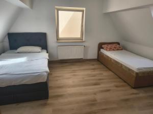 two beds in a small room with a window at Vodita in Höchstadt an der Aisch