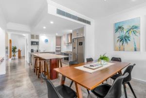 a kitchen and dining room with a table and chairs at The Marron Bloom - Beachfront Boutique Bliss in Palm Cove