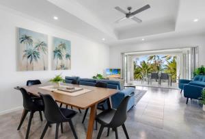 a dining room with a table and blue chairs at The Marron Bloom - Beachfront Boutique Bliss in Palm Cove