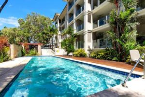 a swimming pool in front of a apartment building at The Marron Bloom - Beachfront Boutique Bliss in Palm Cove +31 photos