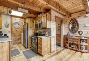 a kitchen with wooden cabinets and appliances in a log cabin at Mountain Dreams in Sevierville