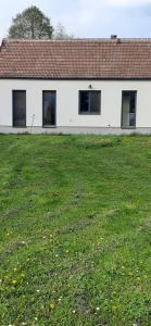 a white building with windows and a grass field at Wein4tel Auszeit in Blumenthal