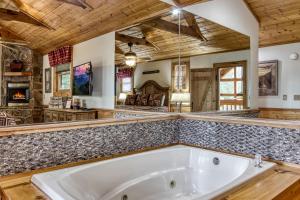 a large bathroom with a tub in the middle of it at Mountain Dreams in Sevierville +28 photos