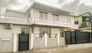 a white house with black doors and a fence at Appartement avec terasse in Bel Air