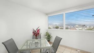 a dining room with a glass table and chairs and a window at 'The Sand Dollar' Central Cairns Chic with Adjacent Studio in Cairns