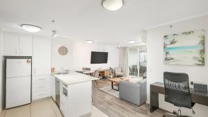 a kitchen and living room with a desk and a couch at 'The Sand Dollar' Central Cairns Chic with Adjacent Studio in Cairns +14 photos