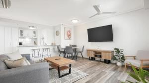 a living room with a couch and a table at 'The Sand Dollar' Central Cairns Chic with Adjacent Studio in Cairns