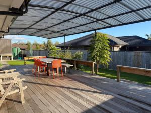 a patio with a table and chairs under a pergola at The Bach in Coromandel Town