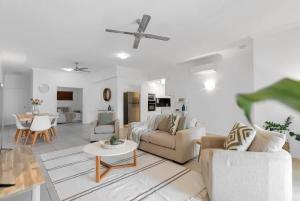 a living room with a couch and a table at 'Eclipse' A Poolside Family Escape in the CBD in Cairns