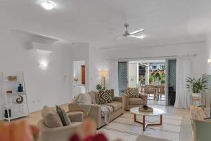 a living room with two couches and a table at 'Eclipse' A Poolside Family Escape in the CBD in Cairns