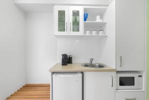a kitchen with white cabinets and a sink at Peak Studio - Highview Haven across Shopping Centre in Cairns +8 photos