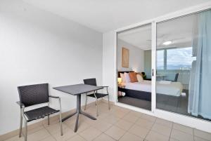 a room with a bed and a table and chairs at McLeod Nook - Poolside Studio by Waterfront & Market in Cairns