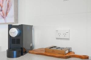 a modem and a box sitting next to a wall at 'Seaside Azul' A Central Studio with Rooftop Pool in Cairns