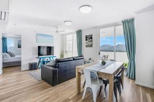 a living room with a dining table and a couch at Cairns City Escape - Elevated Modern Haven with Pool in Cairns
