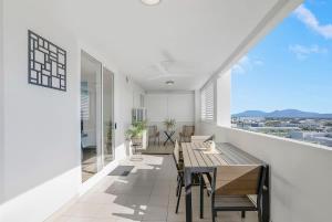 a dining room with a table and chairs on a balcony at Cairns City Escape - Elevated Modern Haven with Pool in Cairns +14 photos