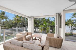a living room with two couches and a table at Turquesa Tides - Beachfront Resort Living in Palm Cove