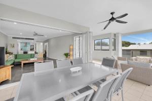 a dining room and living room with a table and chairs at Turquesa Tides - Beachfront Resort Living in Palm Cove +11 photos