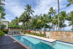 a swimming pool in a villa with palm trees at Turquesa Tides - Beachfront Resort Living in Palm Cove