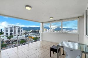 a dining room with a view of a city at McLeod Rise - Cairn Base with Rooftop Pool & Spa in Cairns