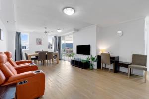 a living room with a couch and a dining room at McLeod Rise - Cairn Base with Rooftop Pool & Spa in Cairns